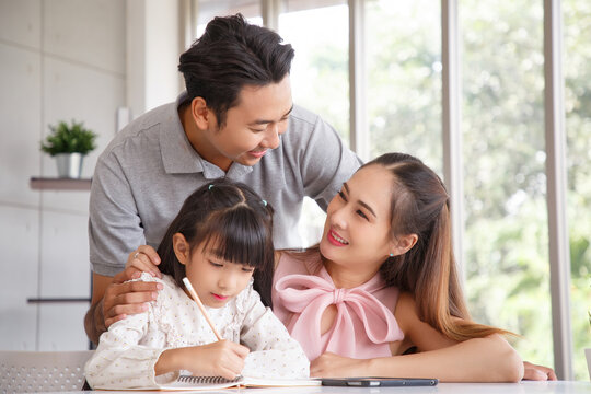 Real estate and mortgage concept : Family with child having activity in new home. Joyful first-time buyers in living room. Real estate, residential mortgage, moving into dream house.