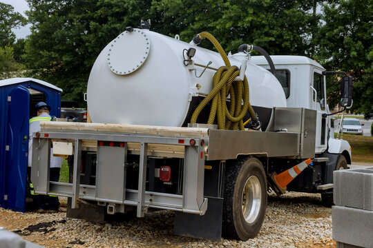 Cleaning A Portable Restroom With A Septic Truck On Construction Site