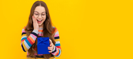 shopping child with purchase. kid with box. happy birthday holiday surprise. Teenager girl with birthday gift, horizontal poster. Banner header with copy space.