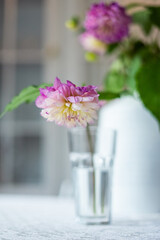 Variety of flowers in a vase on a wooden table in a vintage style room
