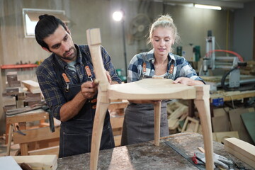 Contemporary Carpenter Working, Portrait of modern carpenter making wood furniture while working in joinery lit by sunlight with factory background on small business concept, copy space