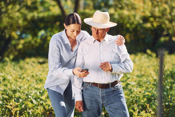 Taking care of garden. Daughter is with her senior father outdoors at daytime