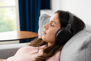 Woman relaxing, listening music at home