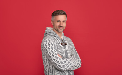 smiling man in sweater on red background, mens beauty