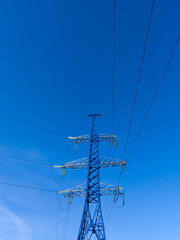 High voltage utility tower on blue sky background