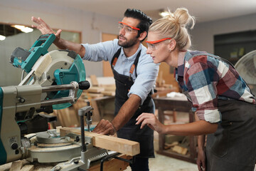 Contemporary Carpenter Working, Portrait of modern carpenter making wood furniture while working in joinery lit by sunlight with factory background on small business concept, copy space