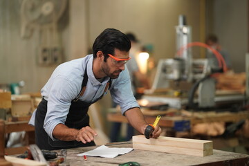 Contemporary Carpenter Working, Portrait of modern carpenter making wood furniture while working in joinery lit by sunlight with factory background on small business concept, copy space