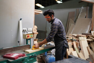 Contemporary Carpenter Working, Portrait of modern carpenter making wood furniture while working in joinery lit by sunlight with factory background on small business concept, copy space
