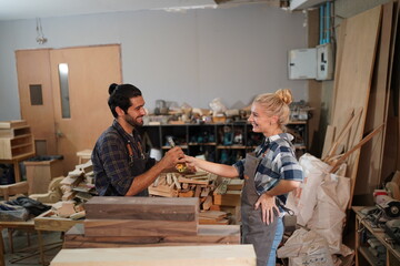 Happy Couple Carpenters have celeabate with a drink bottle after work of Assembling Furniture, Small business in wood DIY workplace office background
