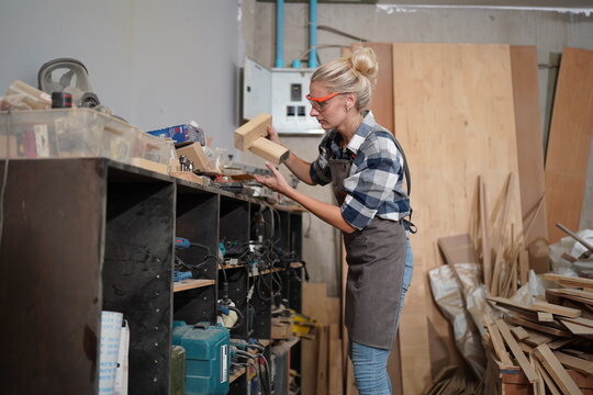 Contemporary Carpenter Working, Portrait Of Modern Carpenter Making Wood Furniture While Working In Joinery Lit By Sunlight With Factory Background On Small Business Concept, Copy Space