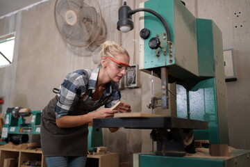 Contemporary Carpenter Working, Portrait of modern carpenter making wood furniture while working in joinery lit by sunlight with factory background on small business concept, copy space