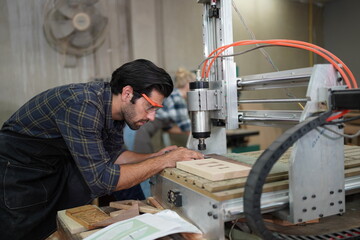 Contemporary Carpenter Working, Portrait of modern carpenter making wood furniture while working in joinery lit by sunlight with factory background on small business concept, copy space