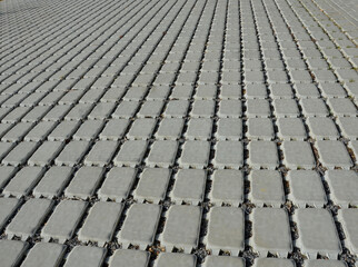 Fototapeta premium absorbent porous paving absorbs a lot of rainwater in a city parking lot. border against vehicles on the shoulder at the entrance to the lawn. infiltration gaps with gravel.