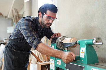 Contemporary Carpenter Working, Portrait of modern carpenter making wood furniture while working in joinery lit by sunlight with factory background on small business concept, copy space