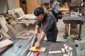 Contemporary Carpenter Working, Portrait of modern carpenter making wood furniture while working in joinery lit by sunlight with factory background on small business concept, copy space