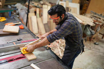 Contemporary Carpenter Working, Portrait of modern carpenter making wood furniture while working in joinery lit by sunlight with factory background on small business concept, copy space