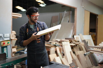Contemporary Carpenter Working, Portrait of modern carpenter making wood furniture while working in joinery lit by sunlight with factory background on small business concept, copy space