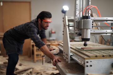 Contemporary Carpenter Working, Portrait of modern carpenter making wood furniture while working in joinery lit by sunlight with factory background on small business concept, copy space