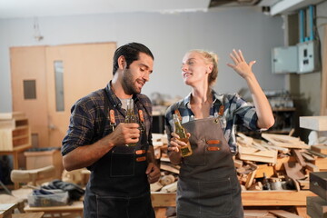 Happy Couple Carpenters have celeabate with a drink bottle after work of Assembling Furniture, Small business in wood DIY workplace office background