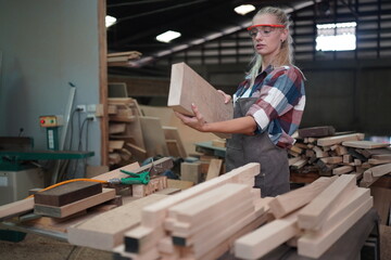 Contemporary Carpenter Working, Portrait of modern carpenter making wood furniture while working in joinery lit by sunlight with factory background on small business concept, copy space