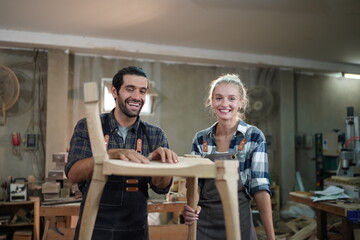 Contemporary Carpenter Working, Portrait of modern carpenter making wood furniture while working in joinery lit by sunlight with factory background on small business concept, copy space