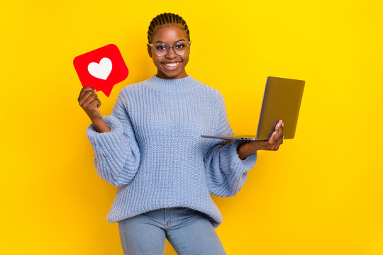 Portrait of young lady bloger wear knitted sweater getting likes new video holding laptop isolated on bright yellow color background - Powered by Adobe