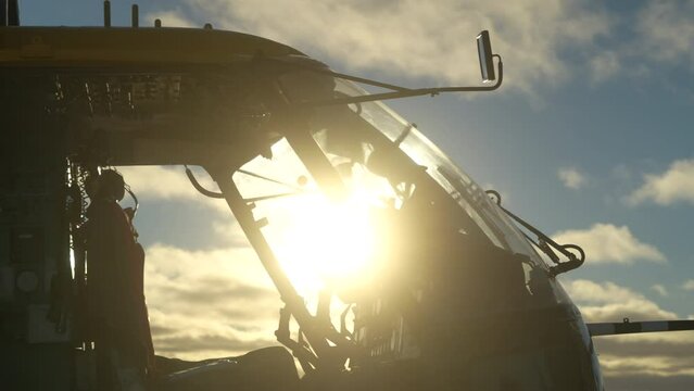 Helicopter cabin in sun. Side view. Door to cabin opened. Cockpit and steering wheels in contour light