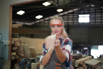 Contemporary Carpenter Working, Portrait of modern carpenter making wood furniture while working in joinery lit by sunlight with factory background on small business concept, copy space