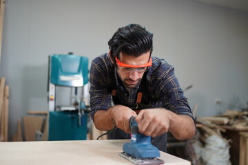 Contemporary Carpenter Working, Portrait of modern carpenter making wood furniture while working in joinery lit by sunlight with factory background on small business concept, copy space