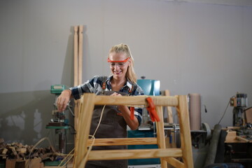 Contemporary Carpenter Working, Portrait of modern carpenter making wood furniture while working in joinery lit by sunlight with factory background on small business concept, copy space