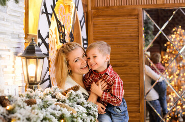 mom holds her little son in her arms, hugs and tickles him, he laughs