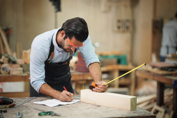 Contemporary Carpenter Working, Portrait of modern carpenter making wood furniture while working in joinery lit by sunlight with factory background on small business concept, copy space