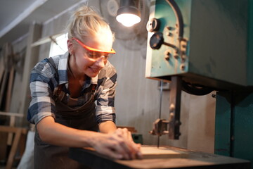 Contemporary Carpenter Working, Portrait of modern carpenter making wood furniture while working in joinery lit by sunlight with factory background on small business concept, copy space
