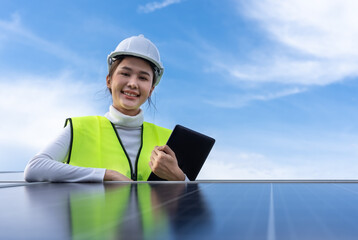 Beautiful Asian female engineer uses a black tablet to inspect solar power station, Clean energy.