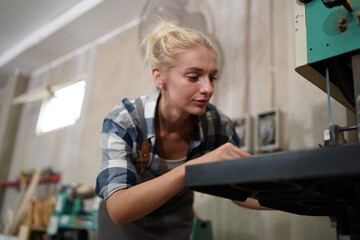 Contemporary Carpenter Working, Portrait of modern carpenter making wood furniture while working in joinery lit by sunlight with factory background on small business concept, copy space