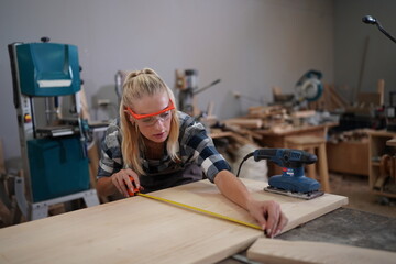 Contemporary Carpenter Working, Portrait of modern carpenter making wood furniture while working in joinery lit by sunlight with factory background on small business concept, copy space