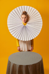 Lamp. Young indifferent girl in giant jabot collar or neckwear and yellow tights isolated over...