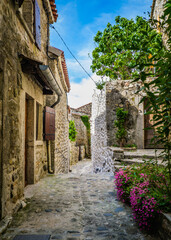 Fototapeta na wymiar View on the narrow but beautiful cobblestone street of the medieval village of Lanas, in the south of France (Ardeche)