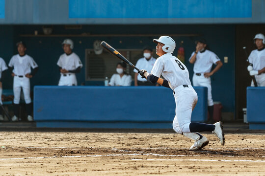 野球の試合でヒットを打つ高校球児
