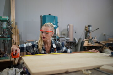 Contemporary Carpenter Working, Portrait of modern carpenter making wood furniture while working in joinery lit by sunlight with factory background on small business concept, copy space