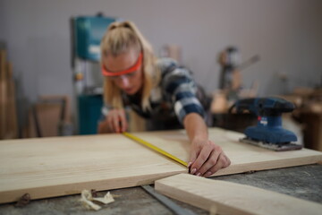 Contemporary Carpenter Working, Portrait of modern carpenter making wood furniture while working in joinery lit by sunlight with factory background on small business concept, copy space