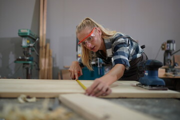 Contemporary Carpenter Working, Portrait of modern carpenter making wood furniture while working in joinery lit by sunlight with factory background on small business concept, copy space