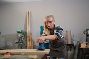 Contemporary Carpenter Working, Portrait of modern carpenter making wood furniture while working in joinery lit by sunlight with factory background on small business concept, copy space