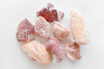 Frozen meat included pork, beef and chicken in cling film or plastic wrap on the table. 