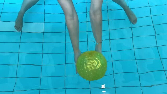 Woman Holding a Yellow Ball Underwater in Slow Motion in Switzerland.