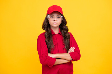 Naklejka premium Worker teenager child wearing overalls red, cap and protect glasses. Studio shot portrait isolated on yellow background.