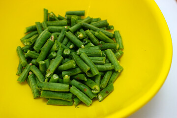 chopped long beans and put in a yellow bowl.Fresh yard long bean have sweet taste and crisp, high nutrition and vitamins. Food and vegetable concept.
