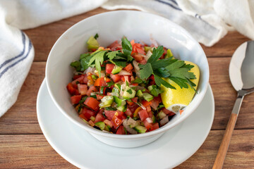Salad on wood background. Salad with tomato, cucumber and pepper. close up
