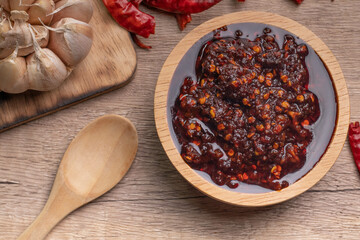 Thai spicy chili paste in a wooden cup (nampnikpao)
