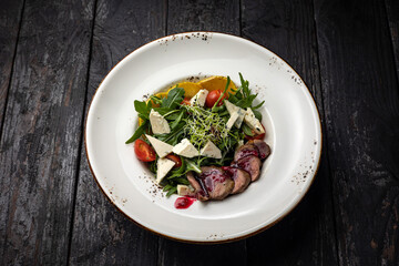 delicious salad in a plate on a dark table
